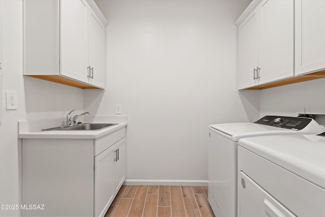 laundry room with sink, separate washer and dryer, and cabinets