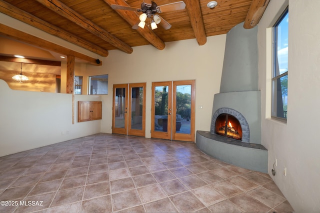 unfurnished living room with beam ceiling, wood ceiling, french doors, and a wealth of natural light