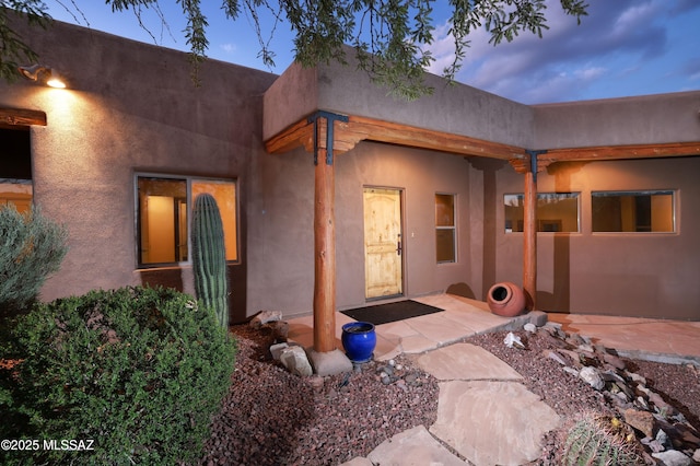 exterior entry at dusk with a patio area