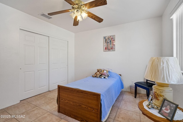 bedroom featuring a closet, light tile patterned flooring, and ceiling fan