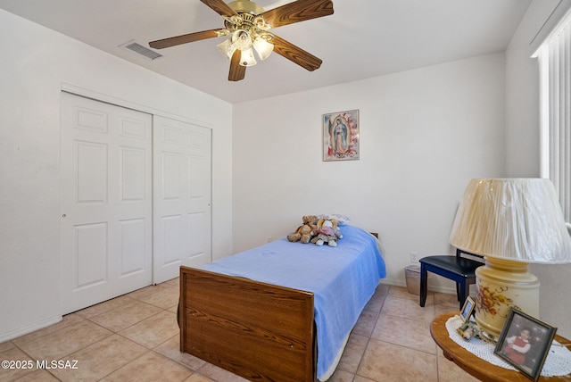 bedroom with ceiling fan, a closet, light tile patterned floors, and visible vents
