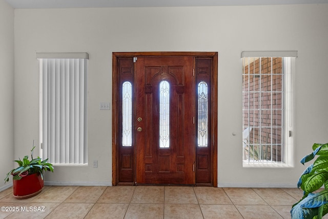 foyer entrance featuring light tile patterned floors and baseboards