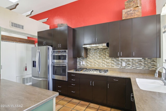 kitchen with sink, stainless steel appliances, dark brown cabinetry, and decorative backsplash