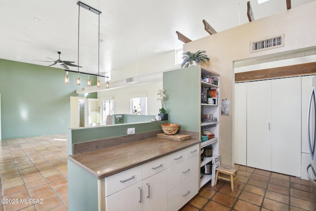 kitchen with ceiling fan, white cabinets, and hanging light fixtures