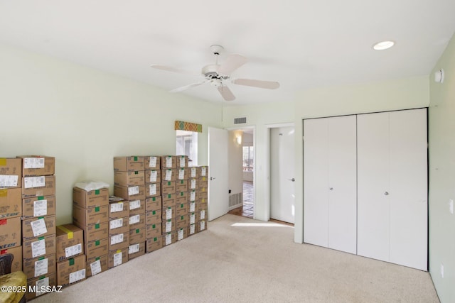 unfurnished bedroom featuring a closet, ceiling fan, and light carpet