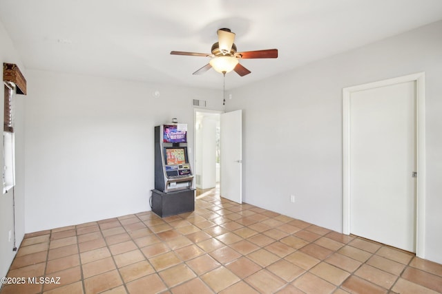 empty room featuring light tile patterned flooring and ceiling fan