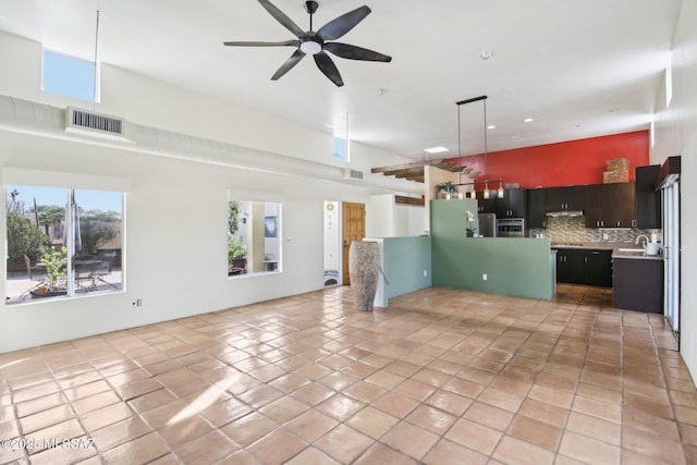 interior space with ceiling fan, oven, fridge, light tile patterned floors, and backsplash