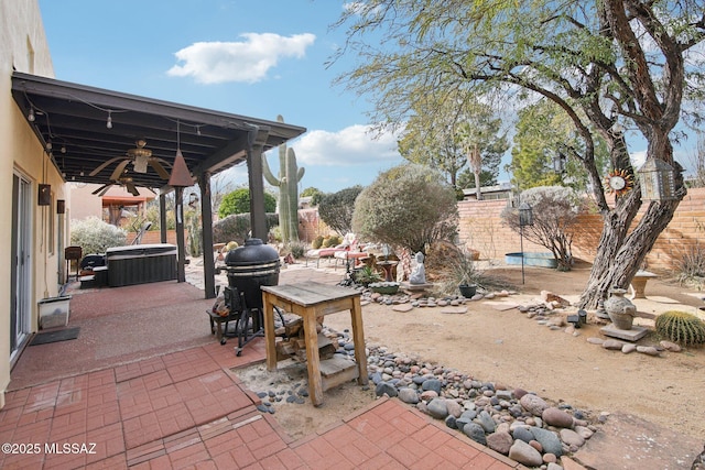 view of patio with a hot tub, a grill, and ceiling fan