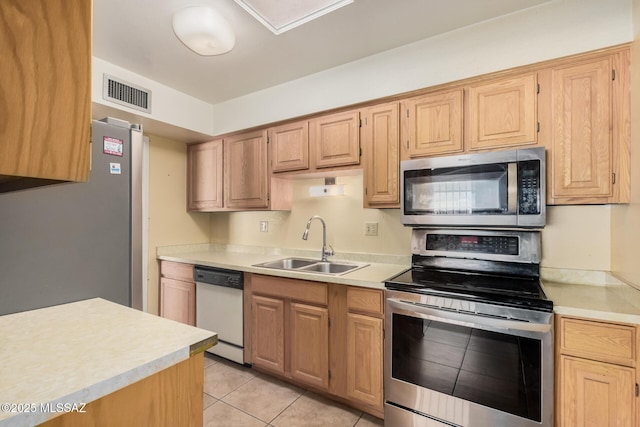 kitchen with sink, stainless steel appliances, light brown cabinetry, and light tile patterned floors