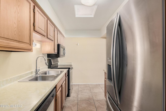 kitchen with light brown cabinetry, appliances with stainless steel finishes, light tile patterned flooring, and sink