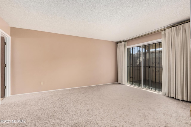 carpeted spare room with a textured ceiling