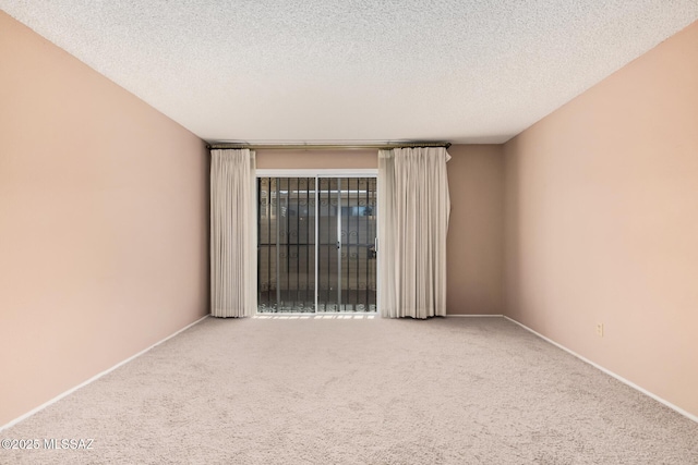 unfurnished room with a textured ceiling and carpet flooring