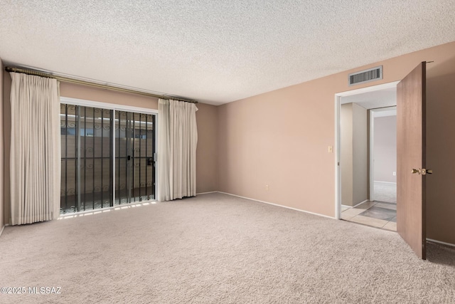 carpeted spare room featuring a textured ceiling