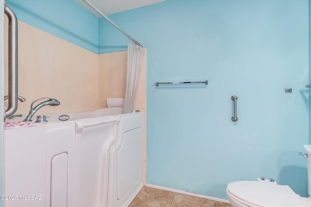 bathroom with toilet and tile patterned floors