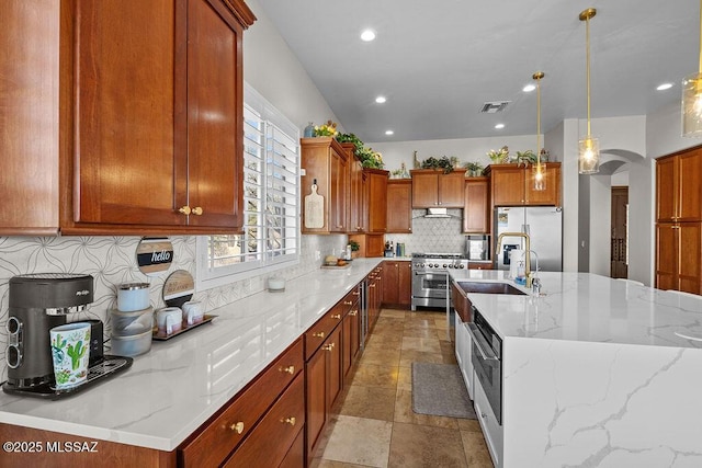 kitchen with arched walkways, stainless steel appliances, stone tile flooring, visible vents, and backsplash