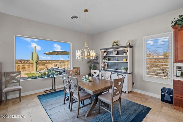 dining room with baseboards, light tile patterned floors, visible vents, and a notable chandelier