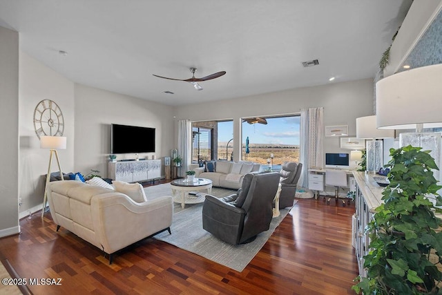 living area with dark wood-style floors, baseboards, visible vents, and a ceiling fan