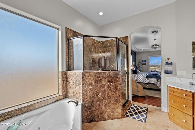 ensuite bathroom featuring a whirlpool tub, a stall shower, visible vents, and connected bathroom