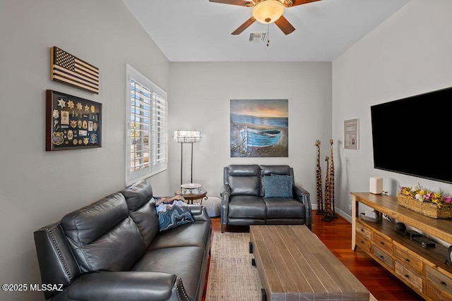 living area with ceiling fan, wood finished floors, visible vents, and baseboards