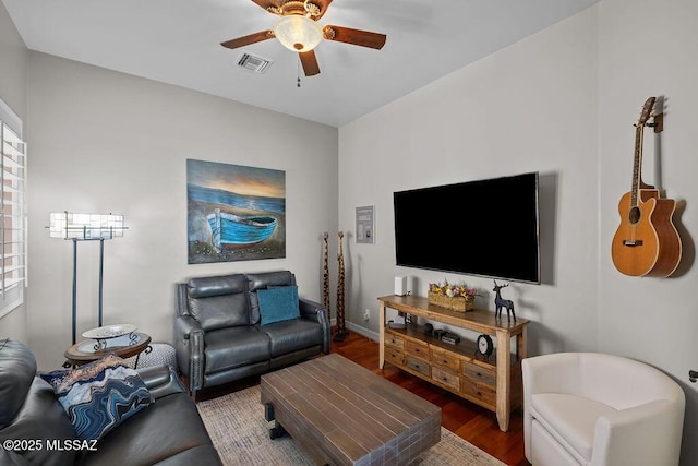 living area with ceiling fan, visible vents, and wood finished floors