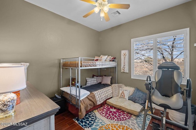 bedroom with a ceiling fan, visible vents, and wood finished floors