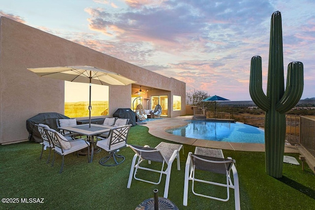 view of pool with a fenced in pool, a ceiling fan, a patio, and a lawn