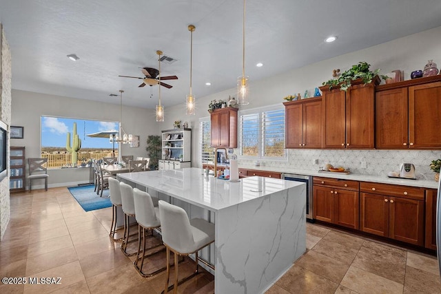 kitchen featuring visible vents, decorative backsplash, dishwasher, brown cabinets, and a healthy amount of sunlight