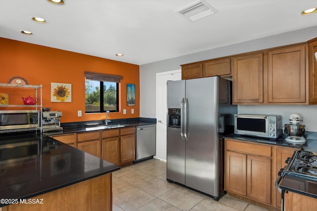 kitchen with light tile patterned floors, appliances with stainless steel finishes, and sink