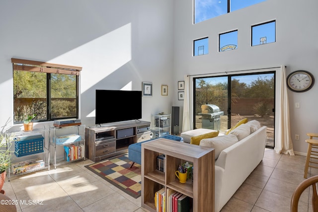 living room featuring light tile patterned floors and a towering ceiling