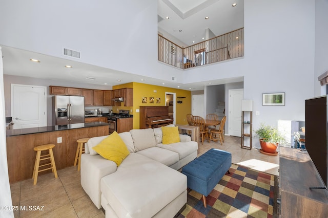 living room featuring light tile patterned floors and a towering ceiling