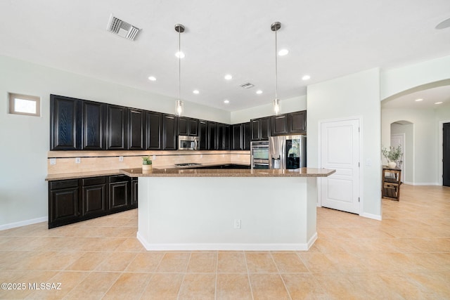 kitchen with light stone countertops, pendant lighting, appliances with stainless steel finishes, light tile patterned flooring, and a center island with sink