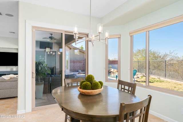 dining space with light tile patterned flooring and ceiling fan with notable chandelier