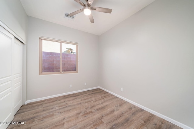 unfurnished bedroom with ceiling fan, a closet, and light wood-type flooring