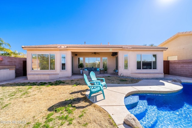 rear view of property featuring ceiling fan, an outdoor living space, and a patio