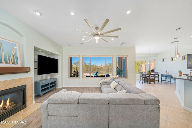 living room with ceiling fan, light tile patterned floors, and a fireplace