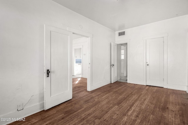 unfurnished bedroom featuring dark hardwood / wood-style flooring