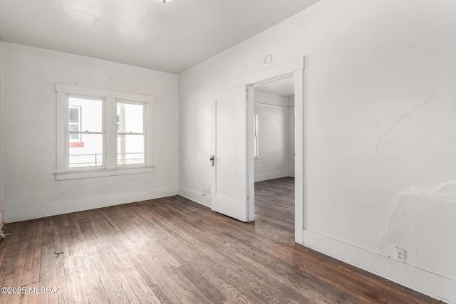 unfurnished room with dark wood-type flooring