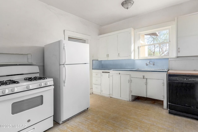 kitchen featuring sink, white appliances, and white cabinets