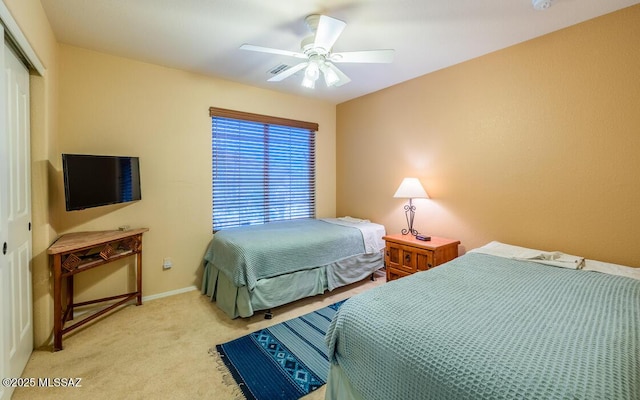 bedroom with light carpet, a closet, and ceiling fan