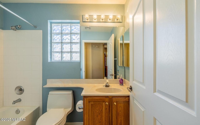 full bathroom featuring toilet, tiled shower / bath, and vanity