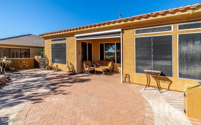 rear view of property featuring an outdoor living space and a patio area