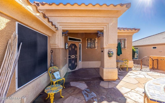 view of exterior entry featuring a patio area