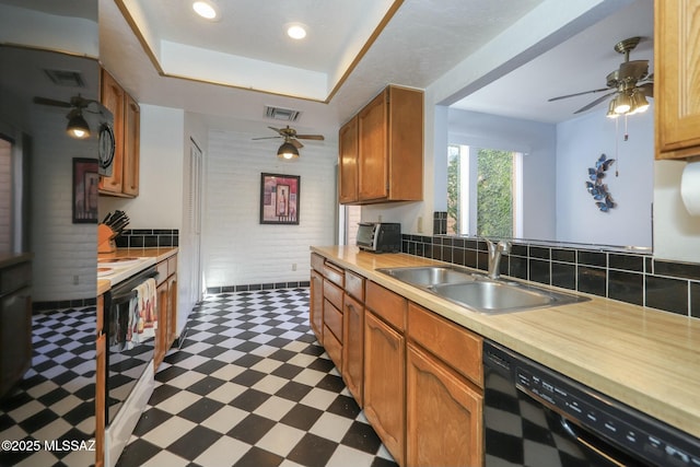 kitchen featuring sink, backsplash, a raised ceiling, and black appliances