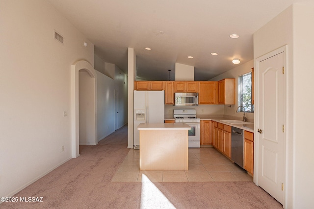 kitchen with vaulted ceiling, light carpet, appliances with stainless steel finishes, a center island, and sink