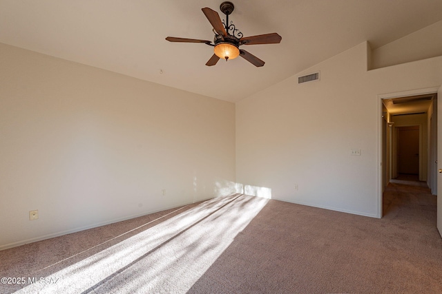 empty room featuring ceiling fan, vaulted ceiling, and carpet floors