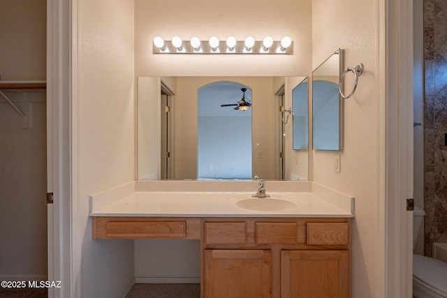 bathroom featuring toilet, ceiling fan, and vanity