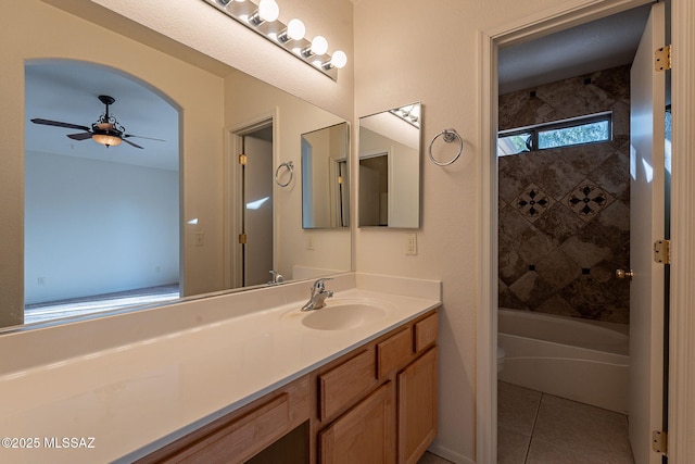 bathroom with ceiling fan, tile patterned flooring, tiled shower / bath combo, and vanity