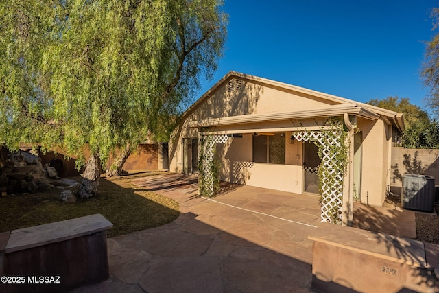 rear view of property with central air condition unit and a patio