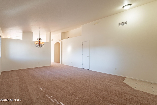 unfurnished room with a notable chandelier and carpet flooring