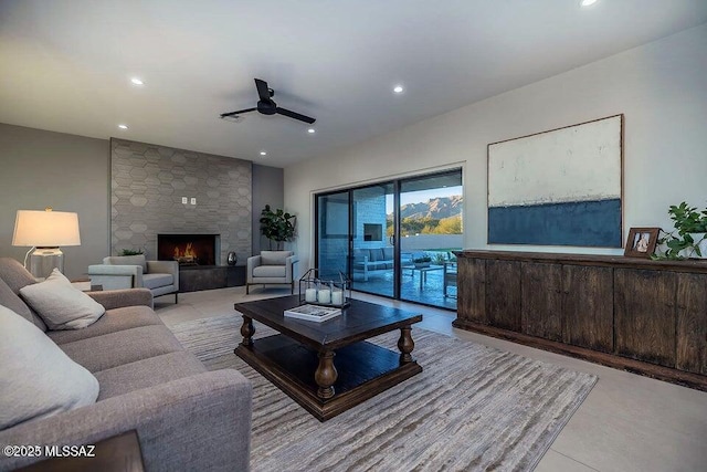 living room with ceiling fan and a stone fireplace